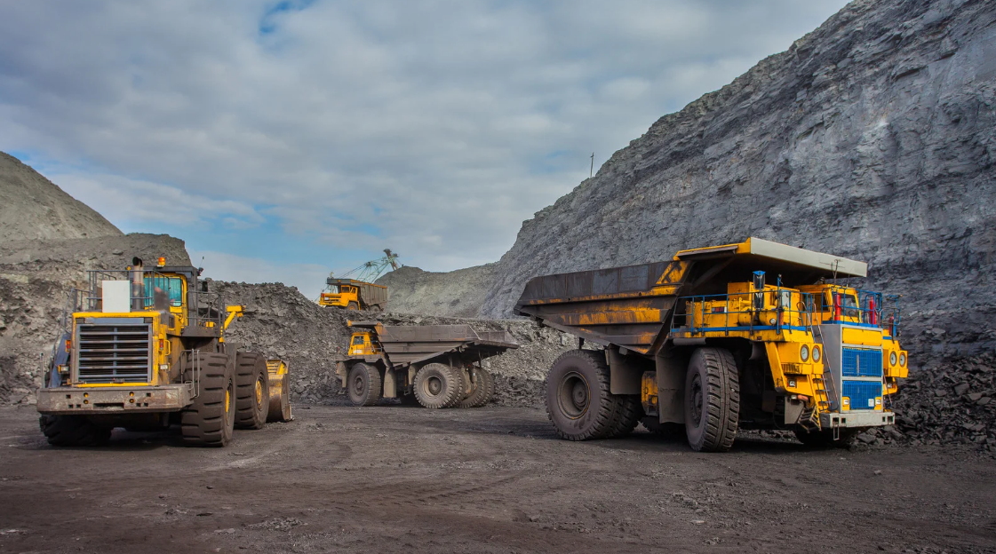 Mining trucks and loader at an active mine site